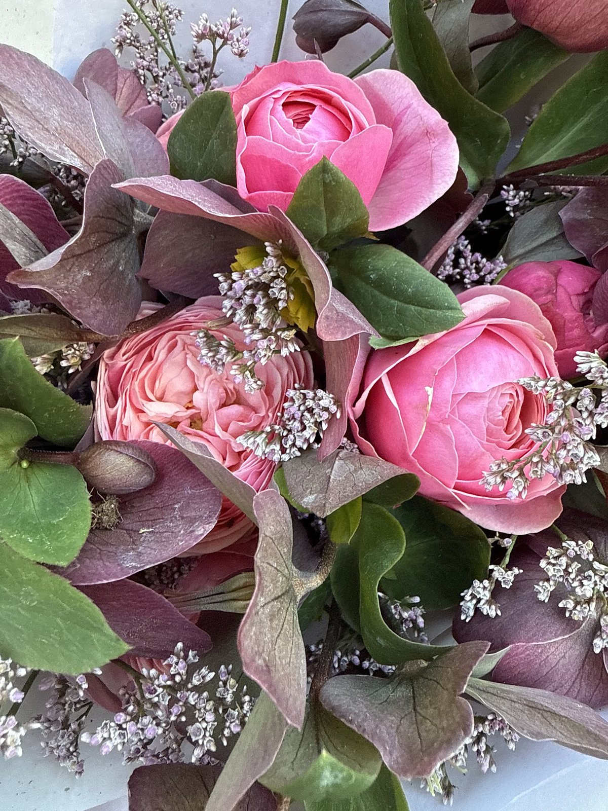 Bouquet fuchsia de renoncules et de feuillages argentés