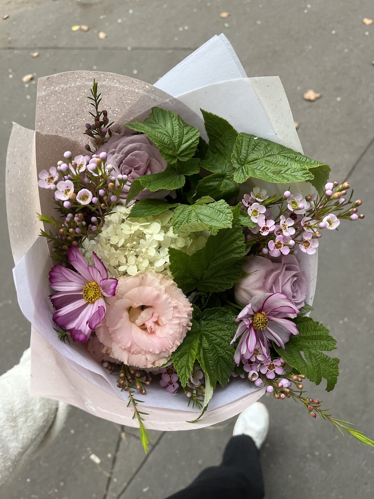 Bouquet pastel emballé dans son papier, prêt à partir