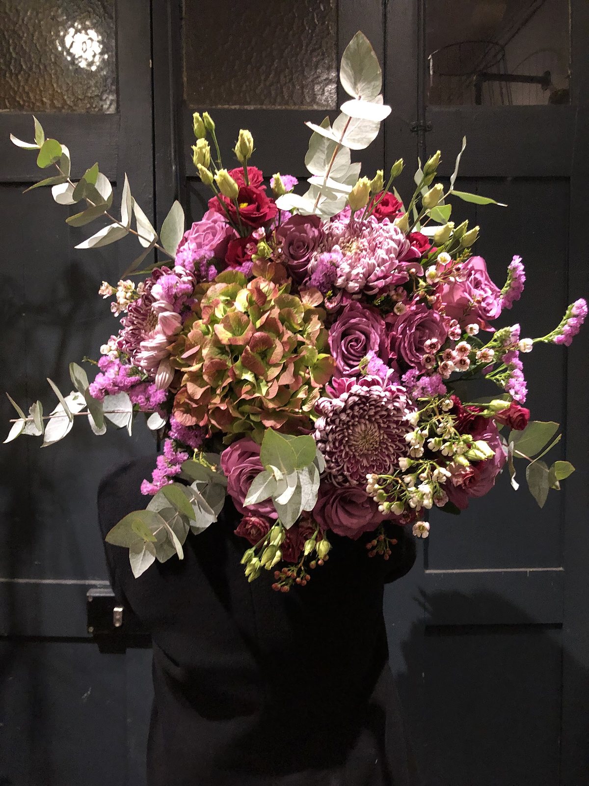 Composition haute rose et verte, orchidées et eucalyptus