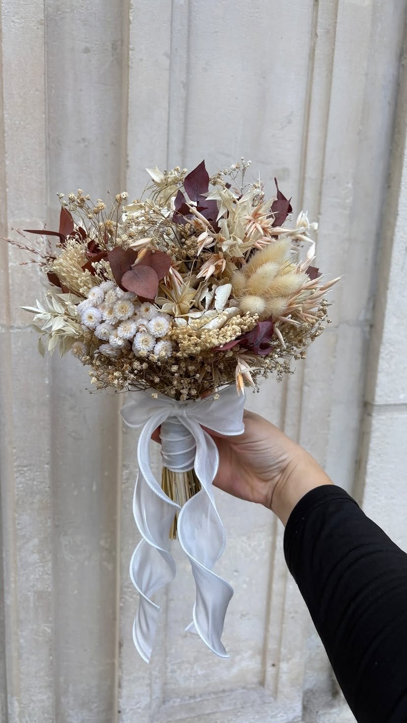 Petite couronne de fleurs séchées suspendue par un ruban